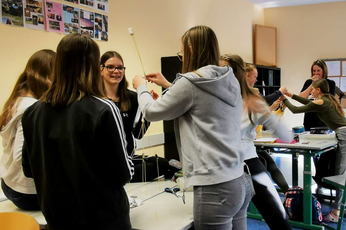 SchülerInnen bauen Turm aus Marshmallows und Spagetthi